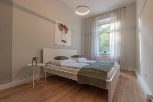 a white bedroom with a bed and a window at Family Apartment in Wiesbaden