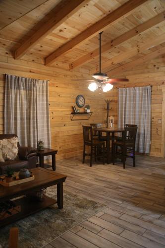 a living room with a dining room table in a cabin at Modern Cabin on wooded 20 acres with scenic view in Nancy, KY in Nancy