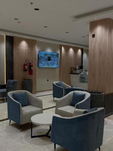 a lobby with couches and chairs and a tv at فندق رافيليا Rafellia Hotel in Ahad Rafidah