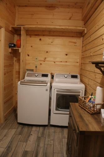 a kitchen with a stove and a washer and dryer at Modern Cabin on wooded 20 acres with scenic view in Nancy, KY in Nancy