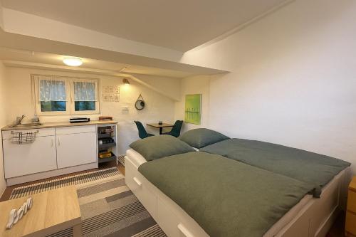 a bedroom with a large bed and a kitchen at Historisches Backhäuschen Studio in Watzelhain