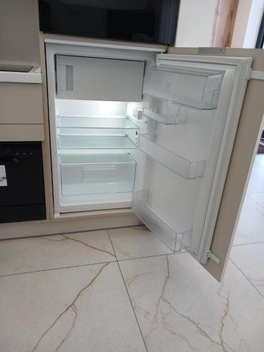 an empty refrigerator with its door open in a kitchen at EcoBerghaus - Котеджне містечко in Bukovel