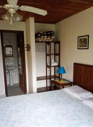 a bedroom with a bed and a ceiling fan at Pousada Arboretum in Penedo