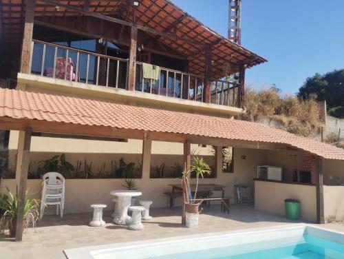 a house with a balcony and a swimming pool at Casa de Tijolinho Penedo-RJ in Penedo