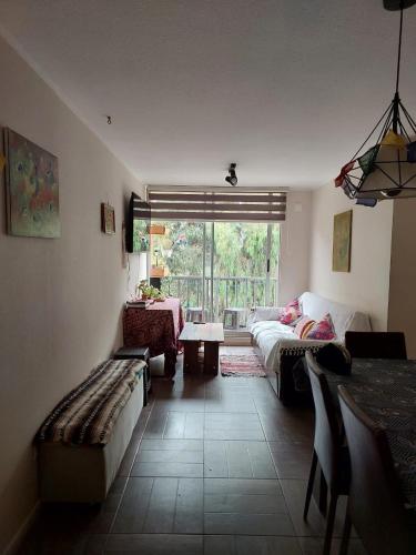 a living room with a couch and a table at Depto cerca playa in La Serena