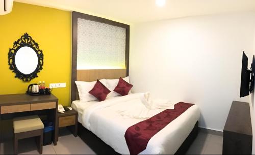 a bedroom with a bed and a table and a mirror at Elite Hotel KL Sentral in Kuala Lumpur