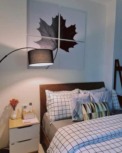 a bedroom with a bed with a leaf on the wall at Stylish and Cozy Earth-tone Studio at Inspiria with Balcony and City-View Free WiFi and Netflix beside Abreeza Mall in Davao City