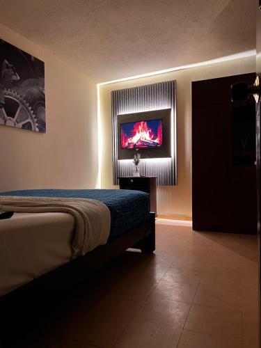 a bedroom with a bed and a tv on the wall at habitación pequeña in Bogotá