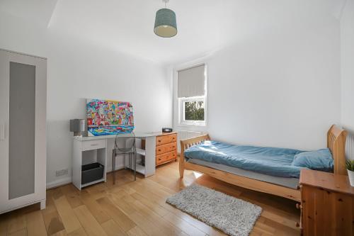 a bedroom with a bed and a desk and a window at Contractors - Businesses - Families - Long term Stays - Free parking in Thornton Heath
