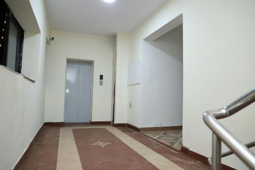 an empty hallway with white walls and a door at Hotel Aranmanai in Coimbatore