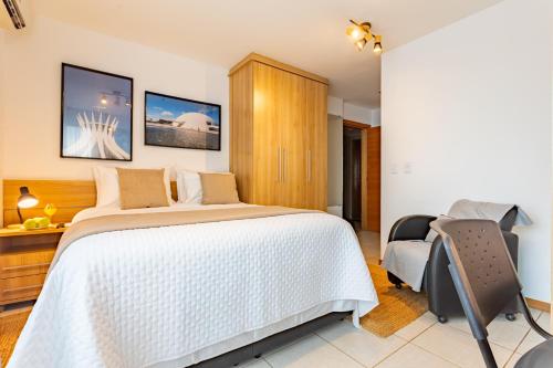 a bedroom with a bed and a desk and a chair at Flat melhor localização Brasilia Biarritz Long Stay in Brasilia