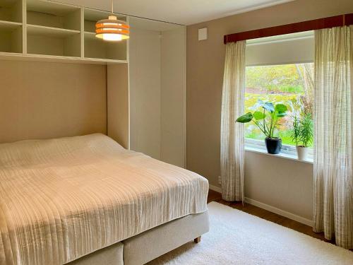 a bedroom with a bed and a window with a potted plant at Embrace The Island Life And Natural Wilderness in Vätö