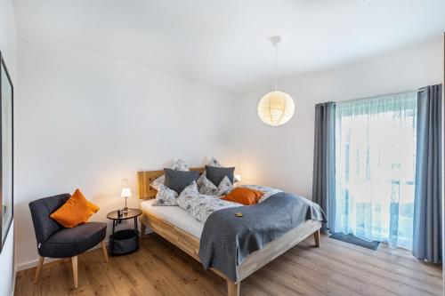 LeutesdorfにあるPunkt15 - Modern - Rollstuhlgerechtのベッドと椅子のある寝室