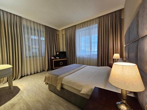 a hotel room with a bed and a large window at Crown Suites in Baku