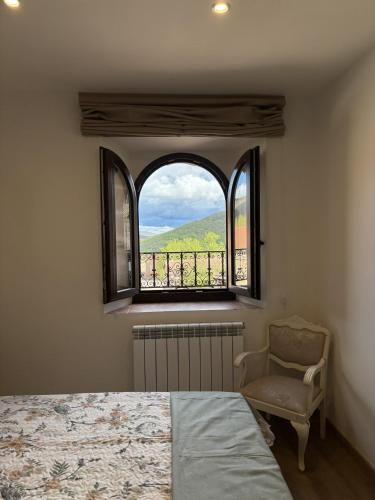 a bedroom with a window and a bed and a chair at Casa Dulcinea en Brañosera in Brañosera