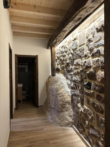 a room with a stone wall and a wooden floor at Casa Dulcinea en Brañosera in Brañosera