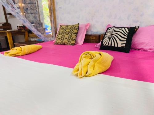 two beds with yellow sheets and pillows on them at Star Rest Surf Camp Arugambay in Arugam Bay