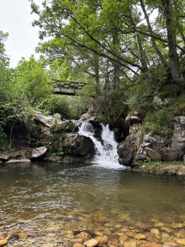 a waterfall in a river with a bridge at Casa Dulcinea en Brañosera in Brañosera