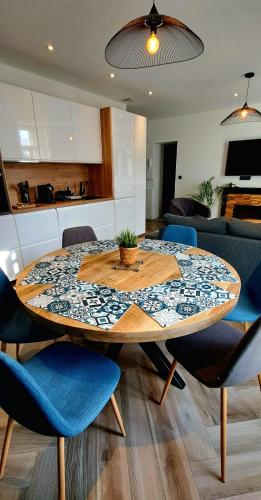 a dining room table with blue chairs and a kitchen at L'indigo, 4-6 pers, 2ch-2sdb, proche cité de la gastronomie in Dijon