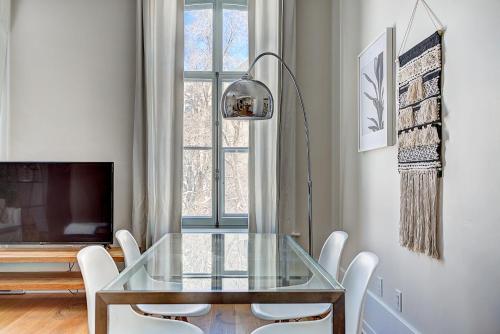 a dining room with a glass table and white chairs at The SFX Old Port in Montréal