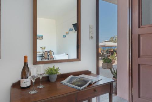 a table with a bottle of wine and a mirror at Frantzis Studio 2 - Nisyros in Páloi