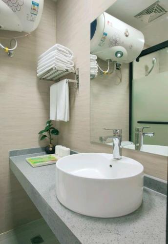 a bathroom with a white sink and a mirror at Spring City Star Hotel Latte Shop in Kunming