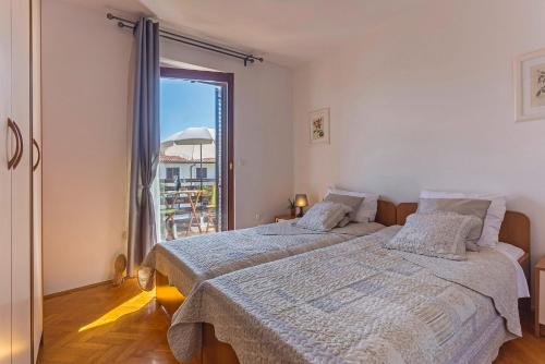 una camera da letto con due letti e una grande finestra di Nada in Vinkuran (Haus für 8 Personen) a Pola (Pula)