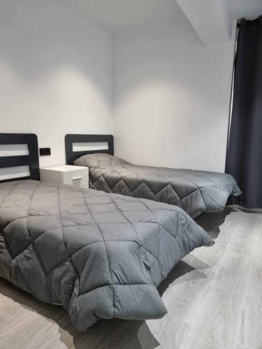 a bedroom with two beds and a bedskirts at Acc Vergara Parking cercano in Jaén