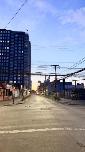 an empty street in a city with a tall building at Epicentro, departamento estudio, sin balcón, con estacionamiento in Temuco