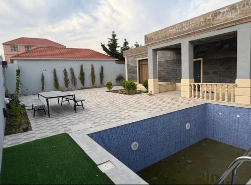 a backyard with a swimming pool and a table at Kiraye in Novxanı