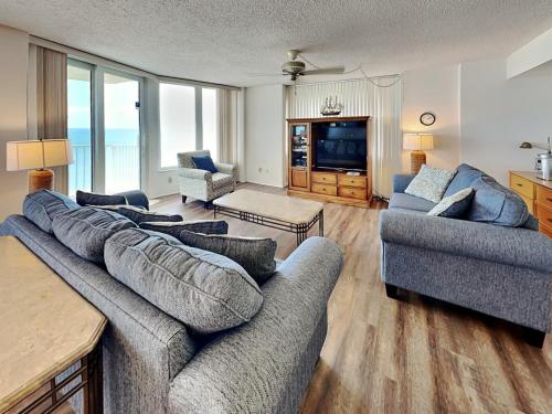 a living room with two couches and a television at Shores Club 807 in Daytona Beach