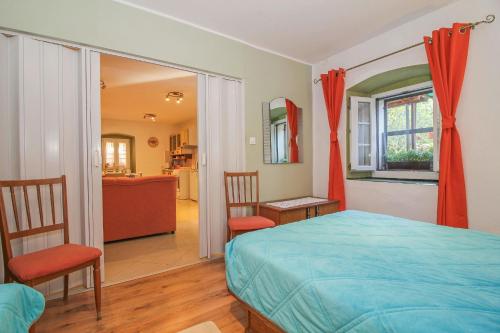 a bedroom with a bed and a living room at Antica in Jakačići - Haus für 2-3 Personen in Gračišće