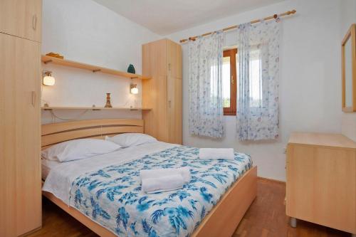 a bedroom with a bed with a blue and white blanket at Villa Theresa in Ližnjan (Haus für 12 Personen) in Ližnjan