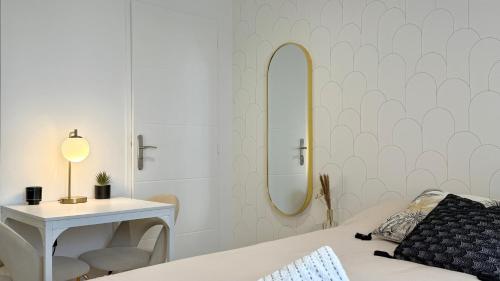 a bedroom with a bed and a table and a mirror at Le Doré Central WiFi in Thoissey