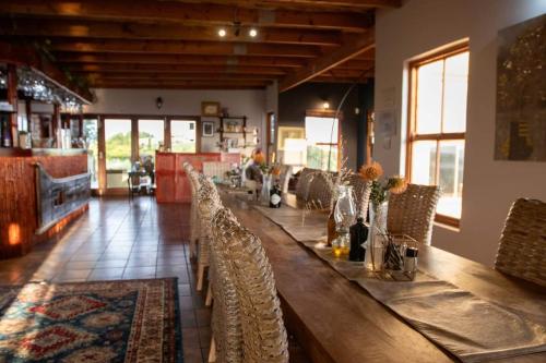 a long wooden table in a restaurant with chairs at Thali Thali Game Lodge in Langebaan