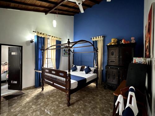 a bedroom with a bed and a blue wall at Moonbeam Villa in Colombo
