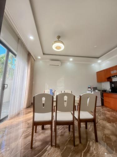 a dining room with a table and four chairs at Phuong Linh Beach Villa in Nha Trang
