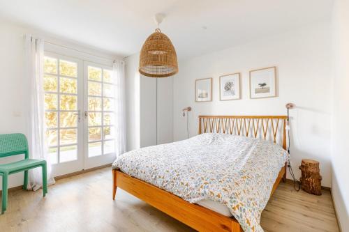 ein Schlafzimmer mit einem Bett und einem grünen Stuhl in der Unterkunft T3 Les Anémones à 50m de la plage avec grande terrasse et grand jardin in Soorts-Hossegor