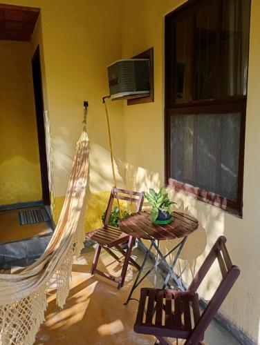 a patio with two chairs and a table and hammock at Pousada Arboretum in Penedo