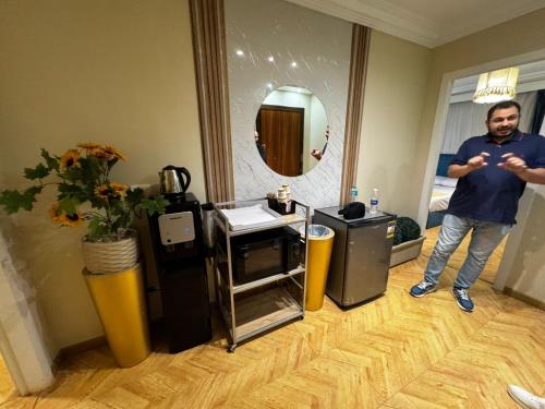 a man standing in a hotel room looking at his cell phone at Villa 53 Hotel by Pharaohs Hospitality in Sheikh Zayed