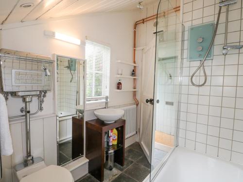 une salle de bain avec un lavabo, des toilettes et une douche dans l'établissement Gun Hill Cottage, à Horam