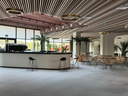 a lobby with a bar with chairs and tables at Hotel BCL Podium La Nucia in La Nucía