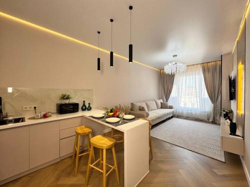 una cucina e un soggiorno con tavolo e sedie di Luxury 2BR Apartment with Stunning View, Estet Residence near MEGA Mall a Almaty