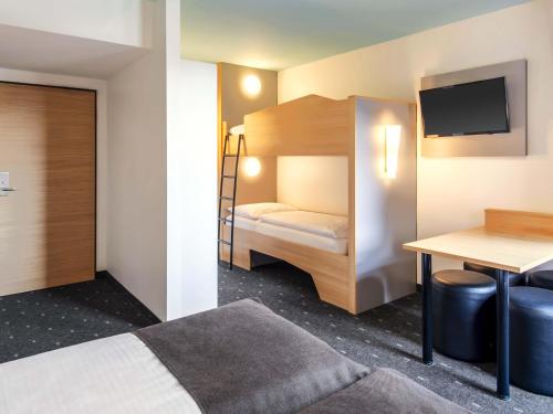 a hotel room with a bunk bed and a desk at B&B Hotel Nürnberg-City in Nürnberg