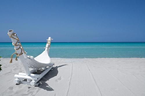a beach chair sitting on the sand on the beach at La Loggetta in Ugento