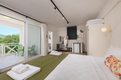 a bedroom with a bed and a large window at Tütsü Pension & Suites in Eskiömerler