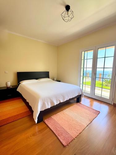 a bedroom with a bed and a large window at Vista Ventura in Ponta Delgada