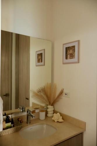 a bathroom with a sink and a large mirror at Modern apartment with direct ocean view in Simón Bolivar