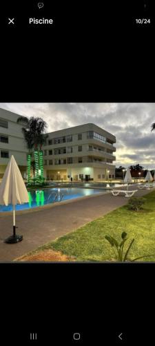 a building with a swimming pool in front of a building at appartement de lux vue piscine 5 min plage bouznika in Bouznika
