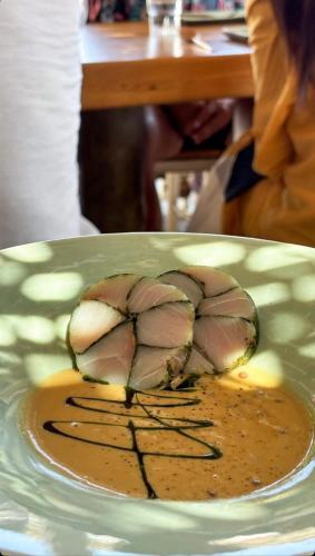 a plate with a chicken cut in half with sauce at Sifnos Blue Horizon House - Endless Blue in Apollonia
